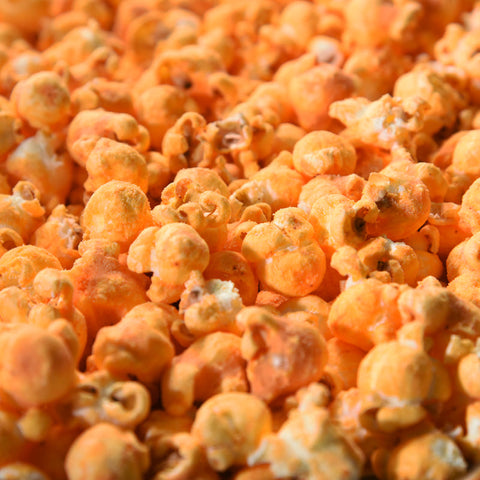 Close up of orange buffalo cheddar gourmet popcorn from Popped! Republic