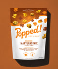 Stand up pouch of Classic Maryland Mixl popcorn on a light brown background