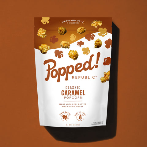 Stand up pouch of Gourmet Caramel popcorn on a brown background