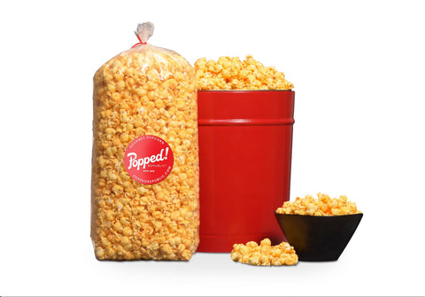 red bucket and extra large bag of spicy gluten free buffalo cheddar popcorn